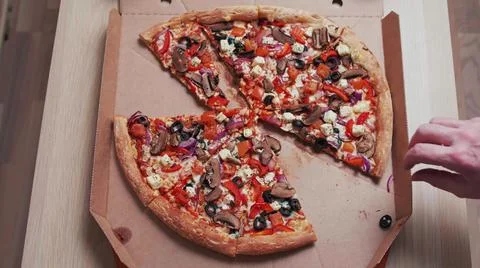 Top view of human hands taking pizza slices with from the delivery box Stock Photos