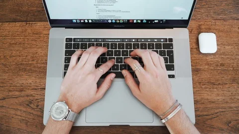 Top view of human hands typing on a laptop keyboard, 4K Stock Footage 129615632