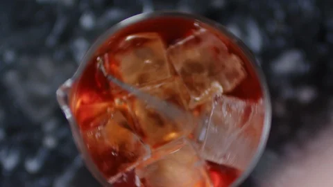 Top view of ice cubes mixing in a glass with drink. Bartender using a long metal Stock Footage 106467170