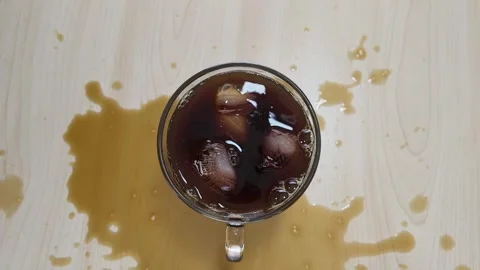 Top View of Iced Black Coffee Spilled on Wooden Table Stock Footage 346356707