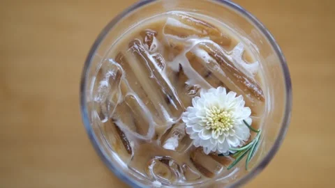 Top view of iced espresso coffee in glass with white flower decoration for cafe Video stock 332144724