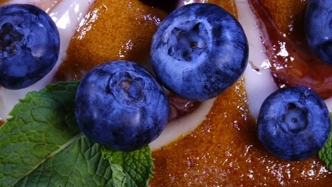 Top-view of iced pie close up with whole fresh blueberries and mint leaves Video stock 78352058