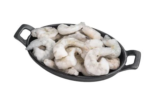 Top view of icy uncooked shellfish (shrimp) in a small black skillet. Prote.. Stock Photos