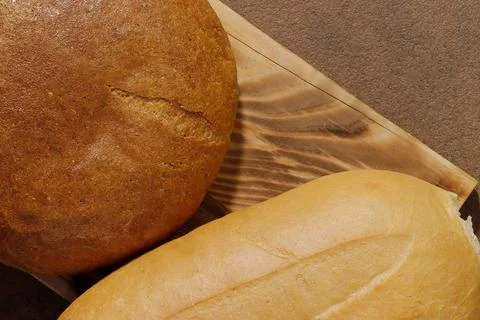 Top view image of gray and white loaves of bread on a kitchen board. Stock Photos