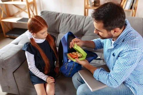 Top view image of responsible father helping his daughter to pack school Stock-Fotos