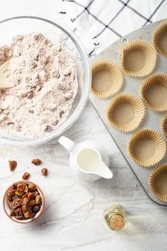 Top view image showing making of delicious fruit and nut cupcake on white mar Stock-Fotos