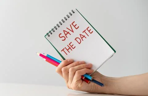 Top view image of table and note with the text Save the Date Stock Photos
