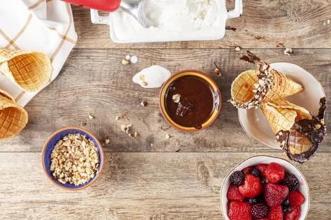 Top view image of a table where hand rolled fresh made waffle cones are dippe Stock Photos
