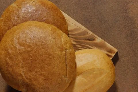 Top view image of three loaves of bread on a kitchen board. Stock Photos