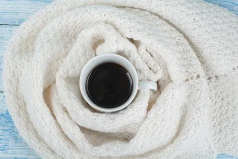 Top view image of white cozy knitted sweater with to cup of coffee on a woo.. Stock Photos
