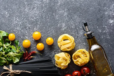 Top view ingredients for dinner-black spaghetti, fettuccine, tomatoes, corn s Stock Photos