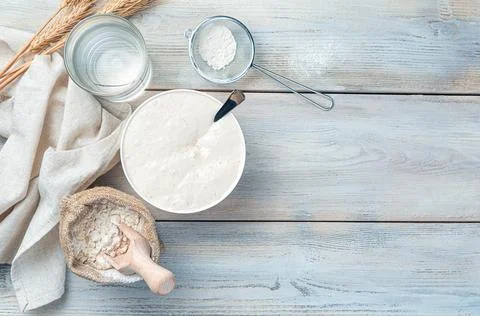 Top view of the ingredients for making bread - a bowl of sourdough, flour in  Stock Photos