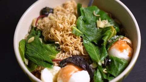 Top View of Instant Ramen Mixed With Delicious Veggies and Poached Eggs in Bowl Stock Footage 105839053