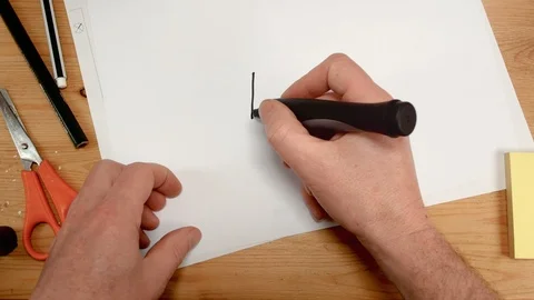 Top view, an interior architect's hand draws a house inside a heart on a sheet Stock Footage 104251028