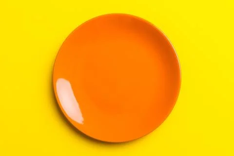 Top view of isolated of colored background empty round orange plate for foo.. Stock Photos