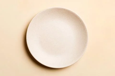 Top view of isolated of colored background empty round beige plate for food.  Stock Photos