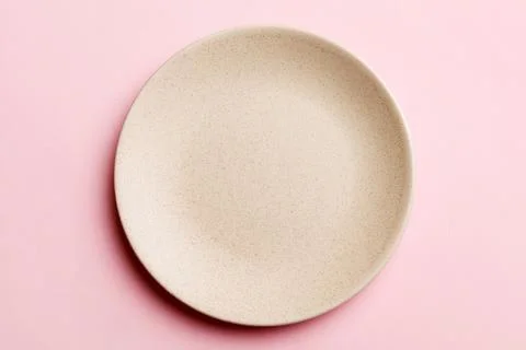 Top view of isolated of colored background empty round beige plate for food.. Stock Photos