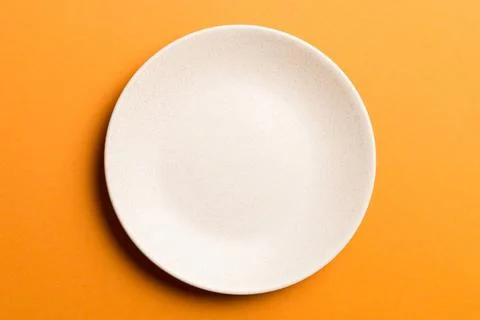 Top view of isolated of colored background empty round beige plate for food.. Stock Photos