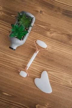 Top view on jade roller,gua sha scraper on the table.Wellness and selfcare Stock Photos