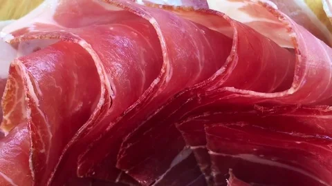 Top view of jamon slices, close up view zoom out. Prosciutto thinly sliced and Stock Footage 77588915