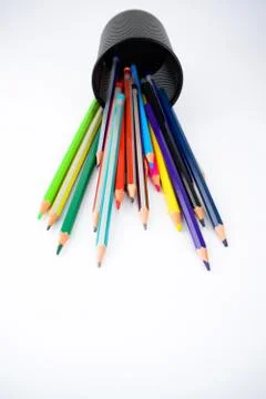 Top view of a jar full of different colored pencil crayons fallen on a white Stock Photos