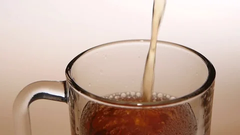 Top view, jet of hot tea fills the glass cup Vidéo 73855266