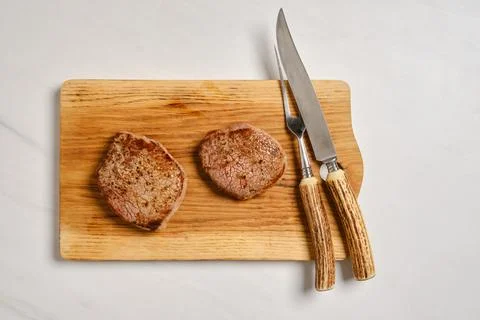 Top view of juicy beef steak on wooden cutting board Stock Photos