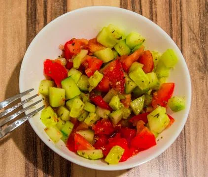 Top view of juicy salad of tomatoes and cucumbers in a white bowl Stock Photos