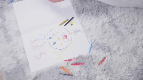 Top view of  kid lying on the floor doing painting with color pencils Stock Footage 163674613