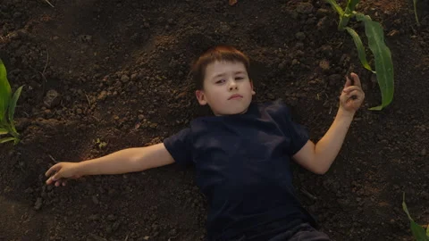 Top view of a kid lying on his back relaxing outside, resting his head on gblack Stock Footage 252108905