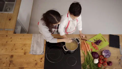 Top view of the kitchen: A single parent family cooking pasta together. Mothe Stock Footage 150664399