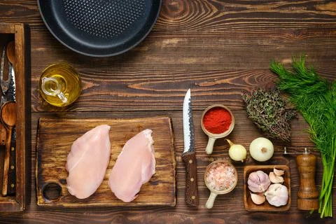 Top view of kitchen table with chicken fillet, aromatic herbs and spices for  Foto stock