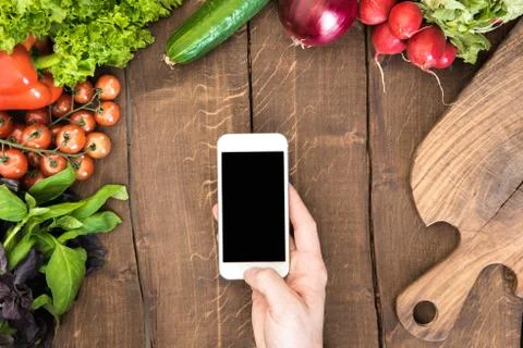 Top view of kitchen table full of various vegetables and human hand holding Stock-Fotos