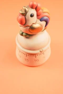 A top view of a kitchen timer in a cute chicken shape on orange background wi Stock Photos