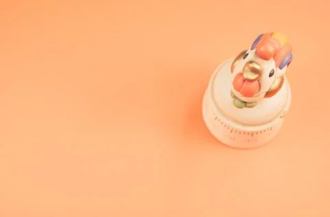 A top view of a kitchen timer in a cute chicken shape on orange background wi Stock Photos