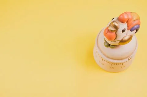 A top view of a kitchen timer in a cute chicken shape on yellow background wi Stock Photos
