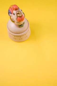 A top view of a kitchen timer in a cute chicken shape on yellow background wi Stock Photos