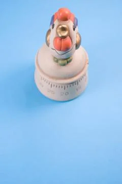 A top view of a kitchen timer in a cute chicken shape on blue background with Stock Photos