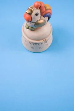 A top view of a kitchen timer in a cute chicken shape on blue background with Stock Photos