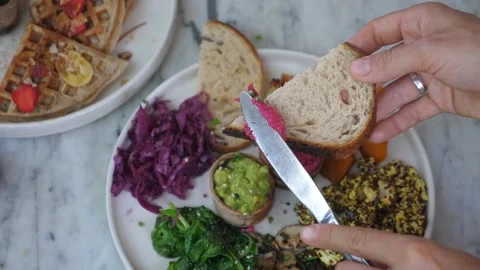 Top view of knife spreading beetroot paste on a toast. Healthy vegan spreads and Video stock 148092754