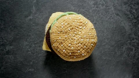 TOP VIEW: Knitted burger falling down on the table. Synthetic food Stock Footage 140626621