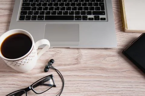 Top view of laptop and notepad with glasses and headphones on wood desktop an Stock Photos