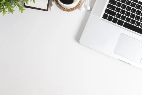 Top view of laptop computer, coffee cup, notebook and potted plant on white.. Foto stock