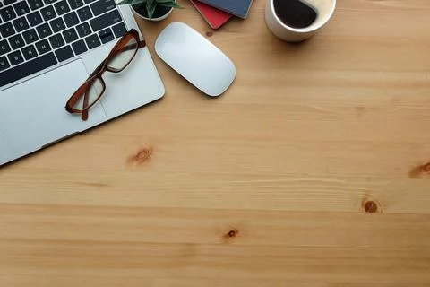 Top view laptop computer, glasses and coffee cup on wooden table. Stock Photos