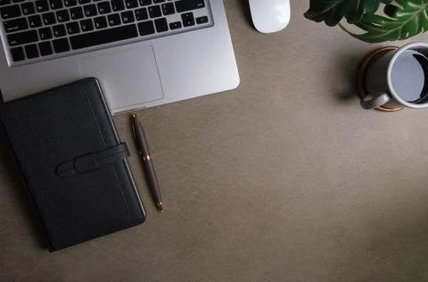 Top view of laptop computer, notepad, coffee cup and potted plant. Stylish .. Stock Photos