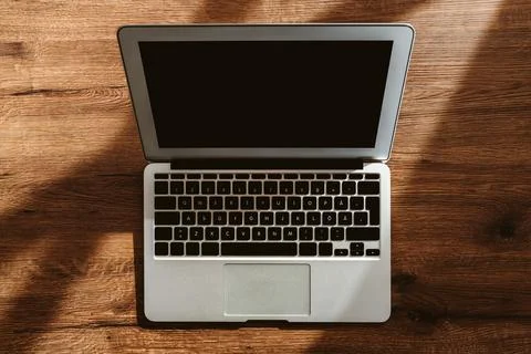 Top view of laptop computer on office desk with blank black mockup screen and Stock Photos