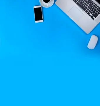 Top view laptop, mouse, smart phone and coffee on blue background. Laptop, mo Stock Photos