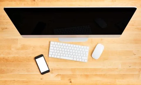 Top view of large desktop computer and smartphone on wooden office desk Foto stock
