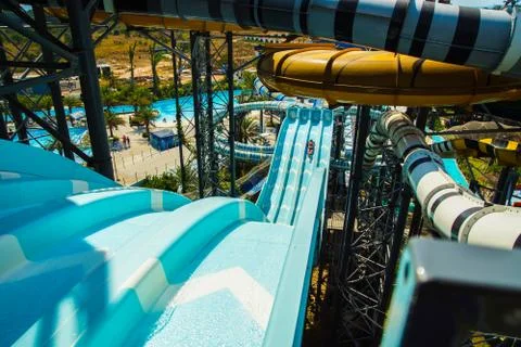 Top view of a large slide in a water park with a man on it. Stock Photos