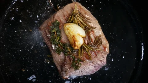 Top view of Large steak is fried in a frying pan in the kitchen of the Stock Footage 107187138